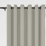 Beige eyelet curtains on a black rod.