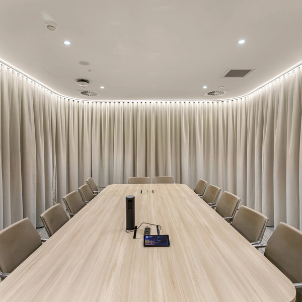 Beige wrap-around curtains in a circular meeting room.