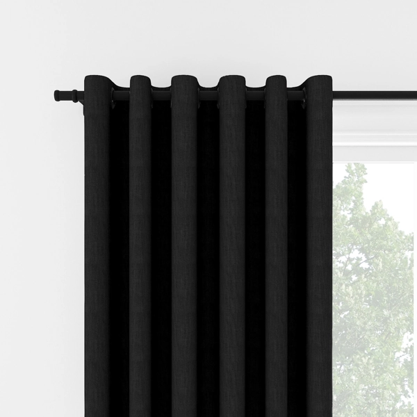 Black eyelet curtains hanging on a black rod.