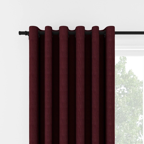 Burgundy eyelet curtains on a black rod