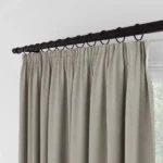 Close-up of beige curtains with ring clips