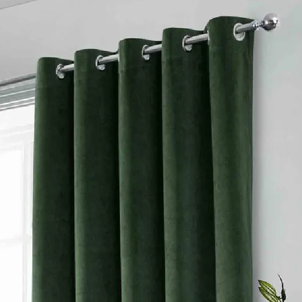 Close-up of dark green velvet eyelet curtain on rod.