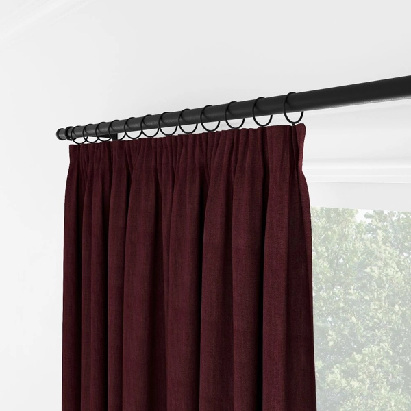Close-up of maroon curtains with black ring hooks