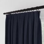 Close-up of navy curtains with ring clips