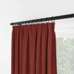 Close-up of red curtains with black ring hooks