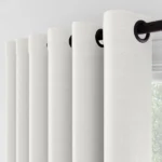 Close-up of white curtains with black grommets