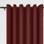 Deep red grommet curtains on a black rod