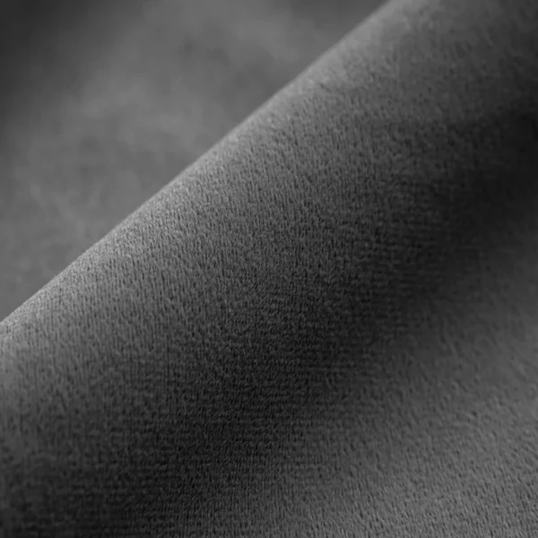 Detailed texture of plush charcoal velvet fabric for curtains.