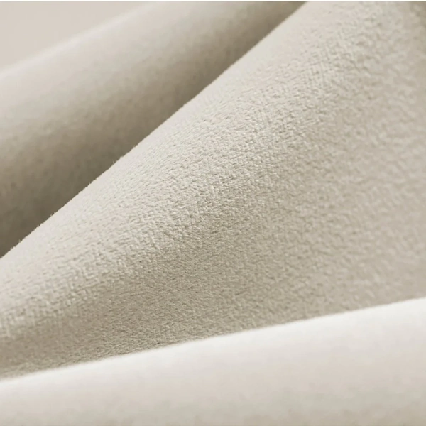 Detailed texture of plush cream velvet fabric for curtains.