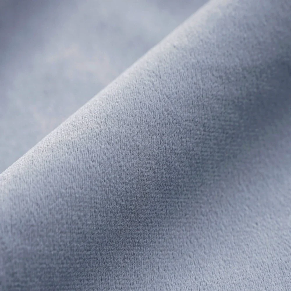 Detailed texture of plush sky blue velvet fabric for curtains.