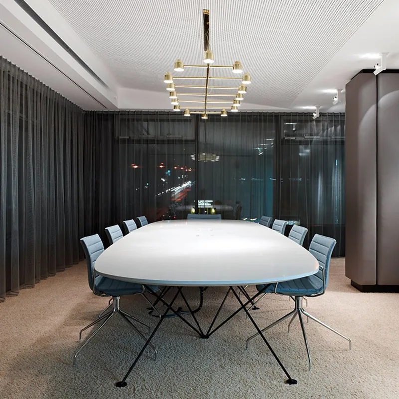 Large oval conference table under a modern chandelier
