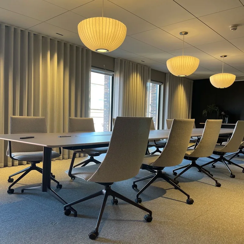 Long conference table with three pendant light fixtures