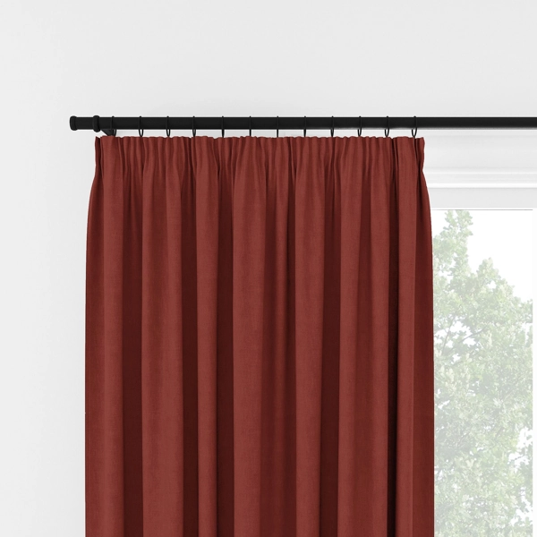 Rust red pleated curtains on a black rod