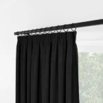 Side angle of black pleated curtains with rings