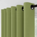 Side view of sage green eyelet curtains and black rod.