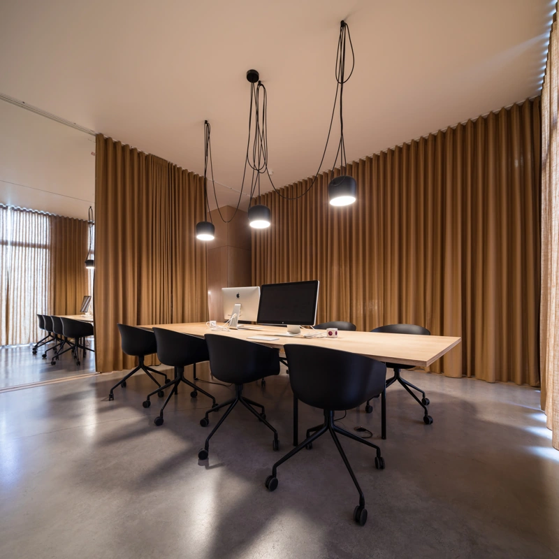 Wood conference table with tan ripple fold curtains